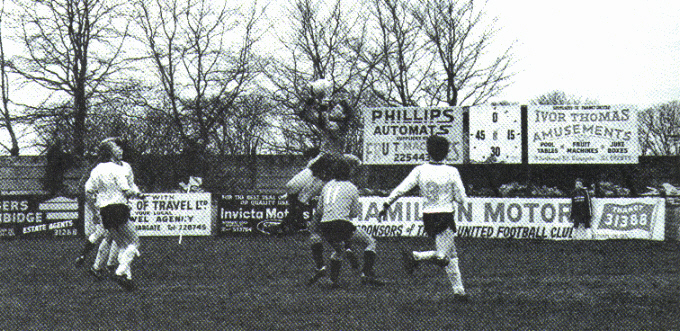 Joe Radford gathers a high ball in front of the old clock at the corner of the Coffin End. The other Thanet players are Ricky Fusco (left) and John Mayall (number 3).