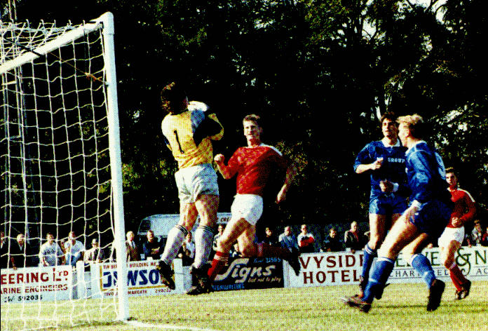 Gravesend's keeper collects as Roy Hales and Paul Underwood look on.