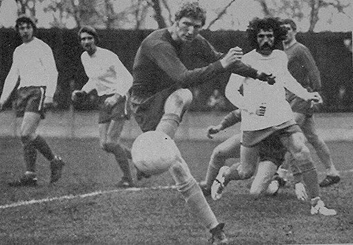 A Guildford defender clears watched by (left to right) Kevin Barry, Henry Hill and the white-booted Barry Brown.