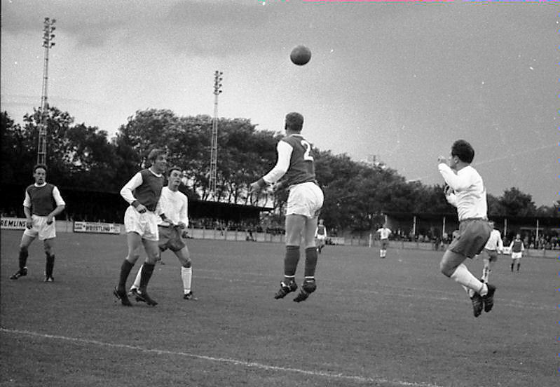 A Folkestone defender and Gordon Burden (right) take off as Dai Yorath looks on.
