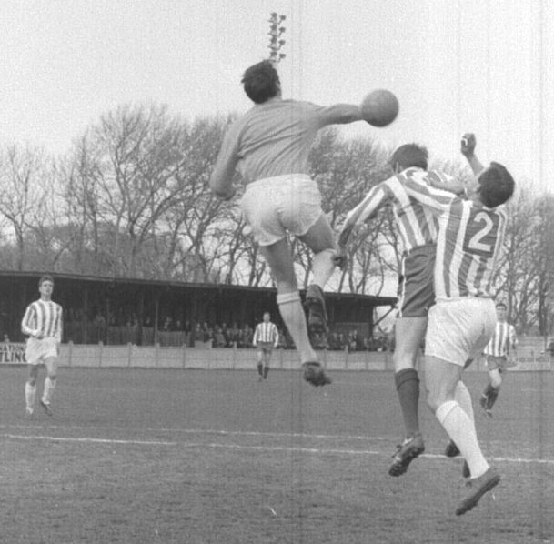 Lennie Long clears under pressure from Dennis Randall.