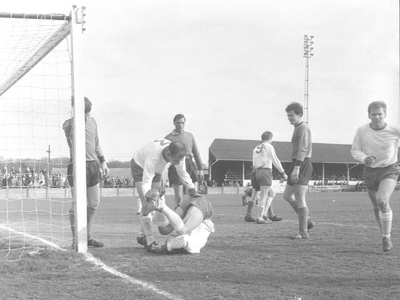 Marshall tends to the injured Thomson as Randall (9) walks away and Ken Bracewell (right) runs towards the camera.